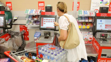 woman using self-checkout in supermarket